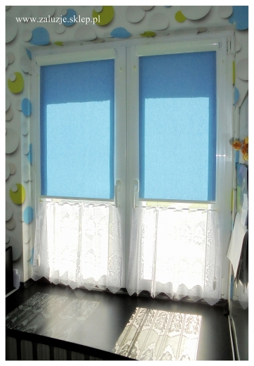     Świeżość i charakter - niebieskie rolety okienne, tworzące przyjemną atmosferę, nadając nowoczesny wygląd pomieszczeniu.